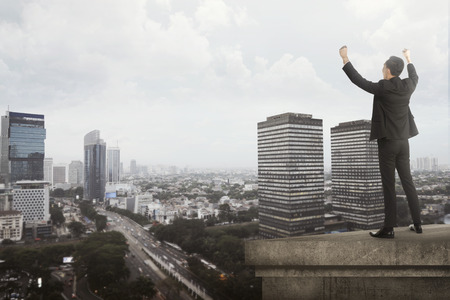 Business man shout on the building rooftop. Success in business conceptの写真素材