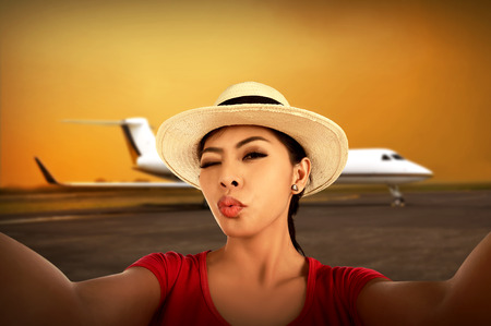 Asian woman take selfie with duck face on the airport. Vacation conceptの写真素材