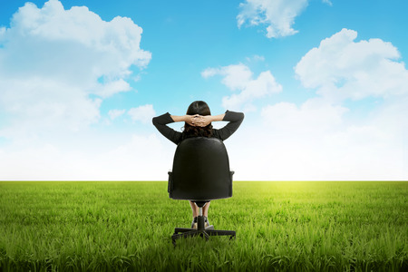 Business woman feeling happy on the meadow at summer timeの写真素材