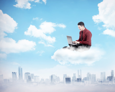 Business man working on the cloud above the city. Cloud computing conceptの写真素材