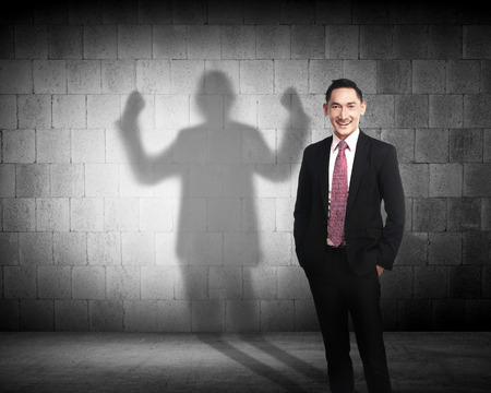Asian business man casting a shadow of strength career conceptの写真素材
