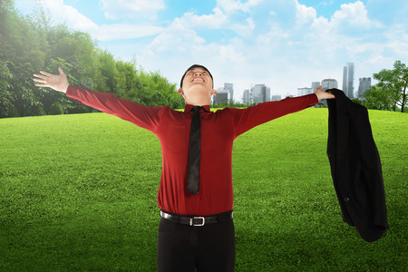 Asian business man open his suit on the city park. Business success conceptの写真素材