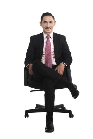 Business man sitting on the chair isolated over white backgroundの写真素材