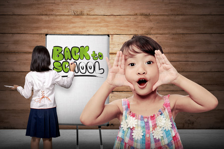 Little girl drawing on canvas back to school writingの写真素材
