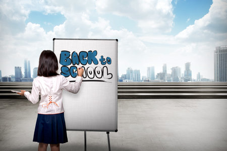 Little girl drawing on canvas back to school writing