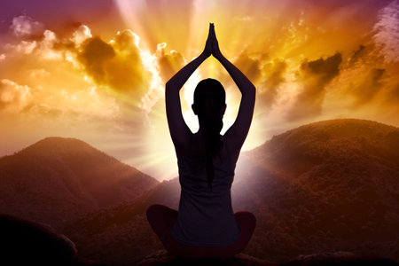 Silhouette of asian woman doing yoga when sunset comeの写真素材