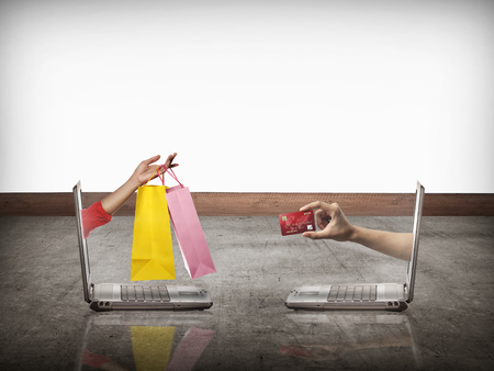 Hand out from computer carry shopping bag, the other show credit card. Online shopping conceptualの写真素材