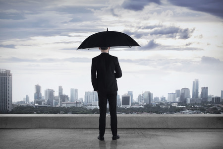 Asian business person, standing on the rooftop, looking the cityの写真素材