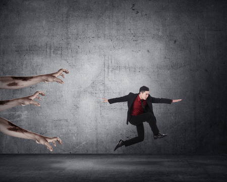 Business man running with zombie. Halloween conceptの写真素材