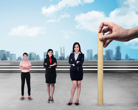 Hand holding wooden ruler, mesuring employee performance. Working appraisal conceptの写真素材