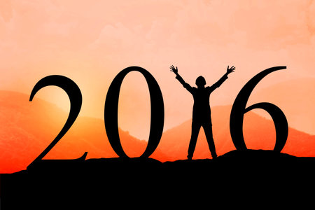 Silhouette of woman jumping over 2016 on the hill at sunset