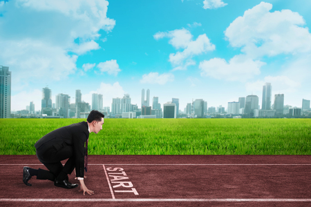 Business person  in ready position to race on the track. Business competition conceptの写真素材