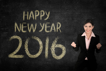 Business woman in front of happy new year 2016 writing. New year concept