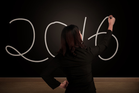 Business woman writing on the chalkboard 2016 number. New year conceptの写真素材