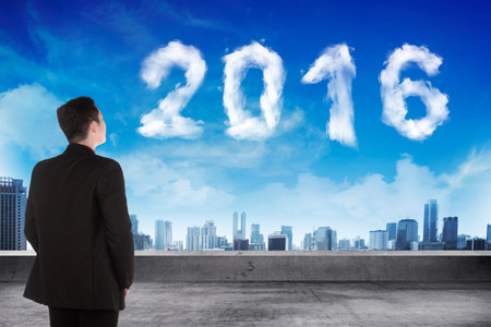 Back view business man looking 2016 cloud on the sky. New year concept