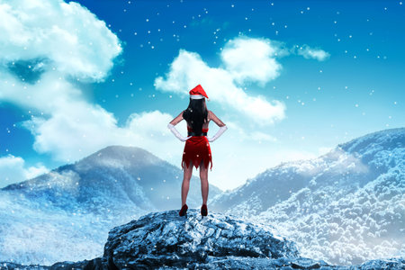 Asian woman wearing santa claus costume standing on the top of mountain looking the skyの写真素材