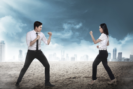 Business man and woman fighting. Working competition conceptの写真素材