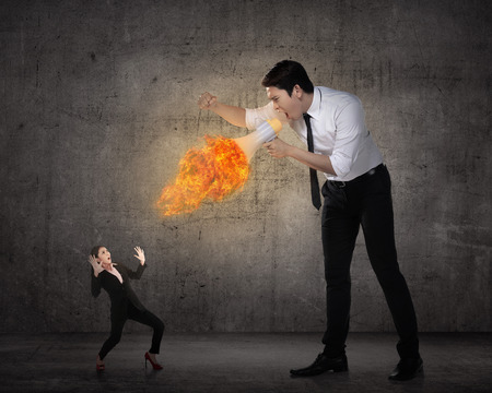 Big boss yelling to her employee with megaphone on fire. Work pressure conceptの写真素材
