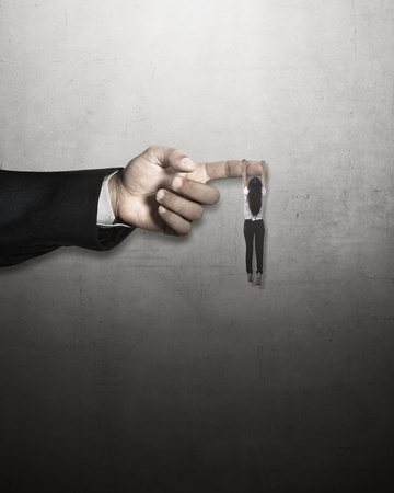 Asian business woman hang on large finger. Help in business conceptの写真素材
