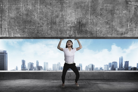Asian business woman lift heavy block. Business challenge conceptの写真素材