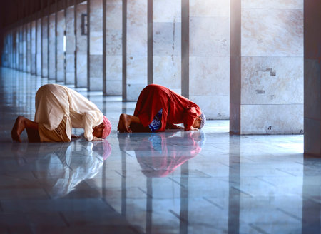 Two religious muslim man praying together inside the mosque