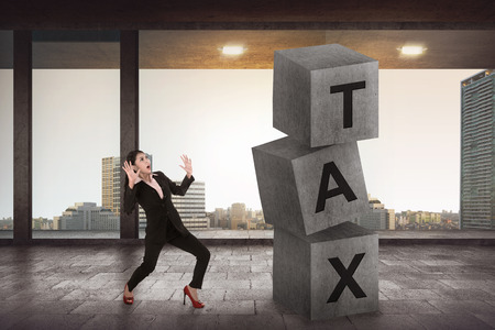 Asian business woman shock looking tax block. Tax calculation conceptの写真素材