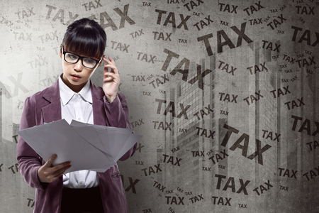 Asian business person thinking hard about tax. Taxation conceptの写真素材