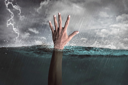 Human hand out from water calling for helpの写真素材