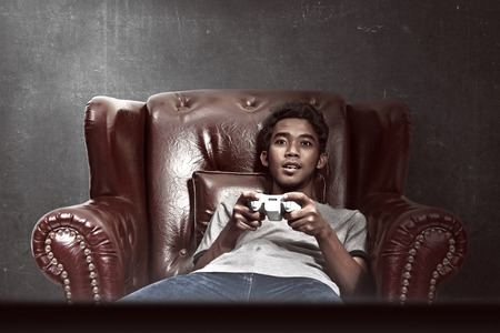 Portrait of asian man playing video games in his living roomの写真素材