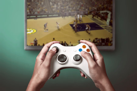 Hand holding game console controller playing sport game on the television
