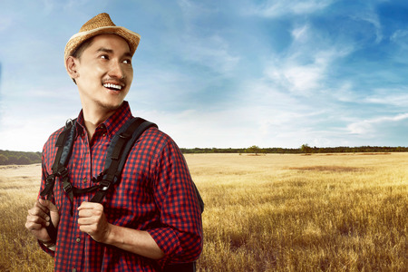 Image of handsome asian man wearing hat travel alone on the savannaの写真素材