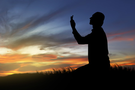Image of silhouette man praying with sunset backgroundの写真素材