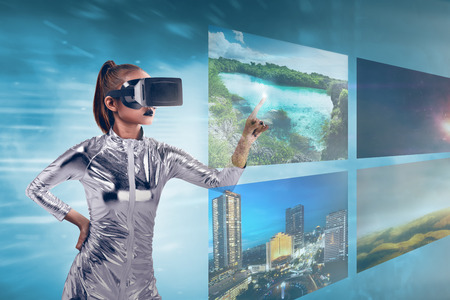 Pretty asian woman wearing silver latex jumpsuit and VR headset inside virtual world. Virtual reality conceptの写真素材
