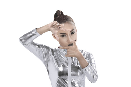 Asian woman wearing silver latex suit framing her head isolated over white background. Futuristic concept imageの写真素材