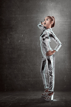 Asian woman wearing latex jumpsuit posing over grunge backgroundの写真素材