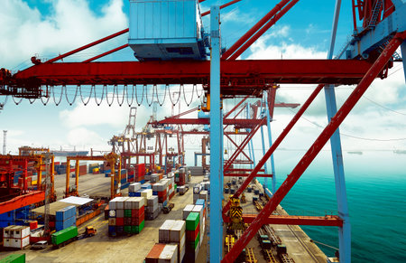 Lots of colorful containers, cranes, and trucks in the back. View from above
