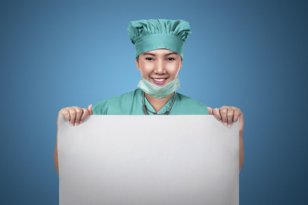Asian female nurse holding empty paper. You can put your design on itの写真素材