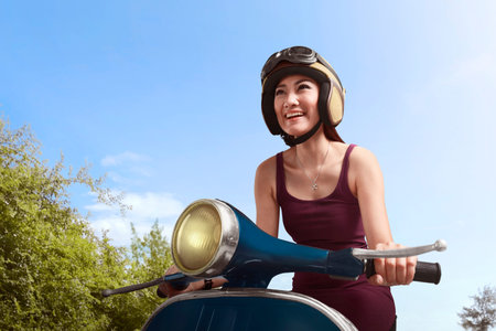 Young beautiful asian woman riding scooter on the street