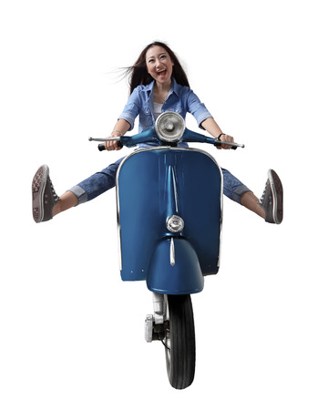 Beautiful young asian woman riding a motorcycle and lift both legs, isolated over white backgroundの写真素材