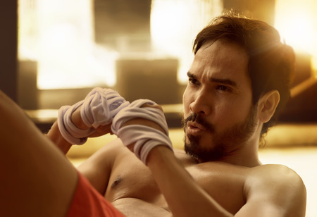 Handsome asian muscular man doing sit-ups on the floorの写真素材