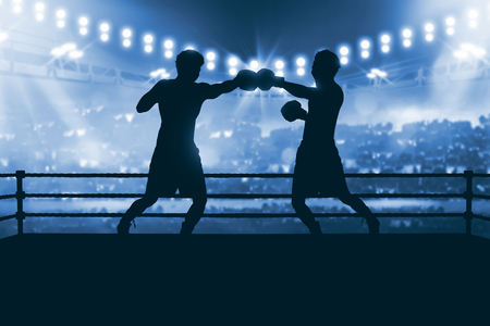 Silhouette of two professional asian boxer fight in the boxing match against stadium spotlightの写真素材