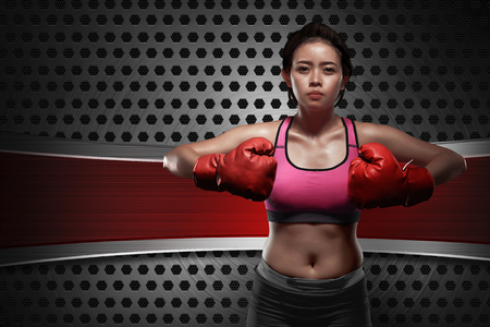 Young asian boxer woman with red gloves against colored backgroundの写真素材
