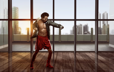 Portrait of asian man practicing boxing against skyscraper backgroundの写真素材