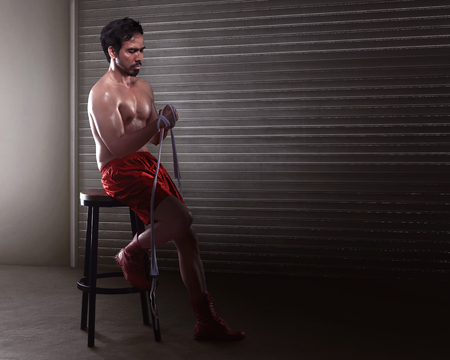 Asian man boxer sitting while wearing white strap on wristの写真素材