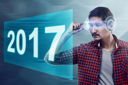 Young asian man wear VR headset looking into 2017 number. Happy new year conceptの写真素材