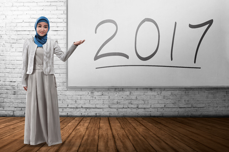 Smiling muslim business woman showing 2017 on the board. Happy new year conceptの写真素材