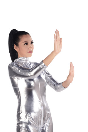 Asian woman wearing silver latex suit isolated over white background. Futuristic concept imageの写真素材