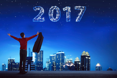 Back view business man looking 2017 on the sky. New year concept