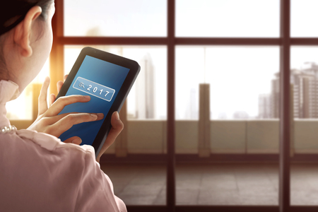Asian business woman touch tablet with 2017 number. New year conceptの写真素材