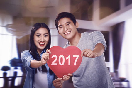 Asian couple holding heart sign with happy new year 2017 typingの写真素材